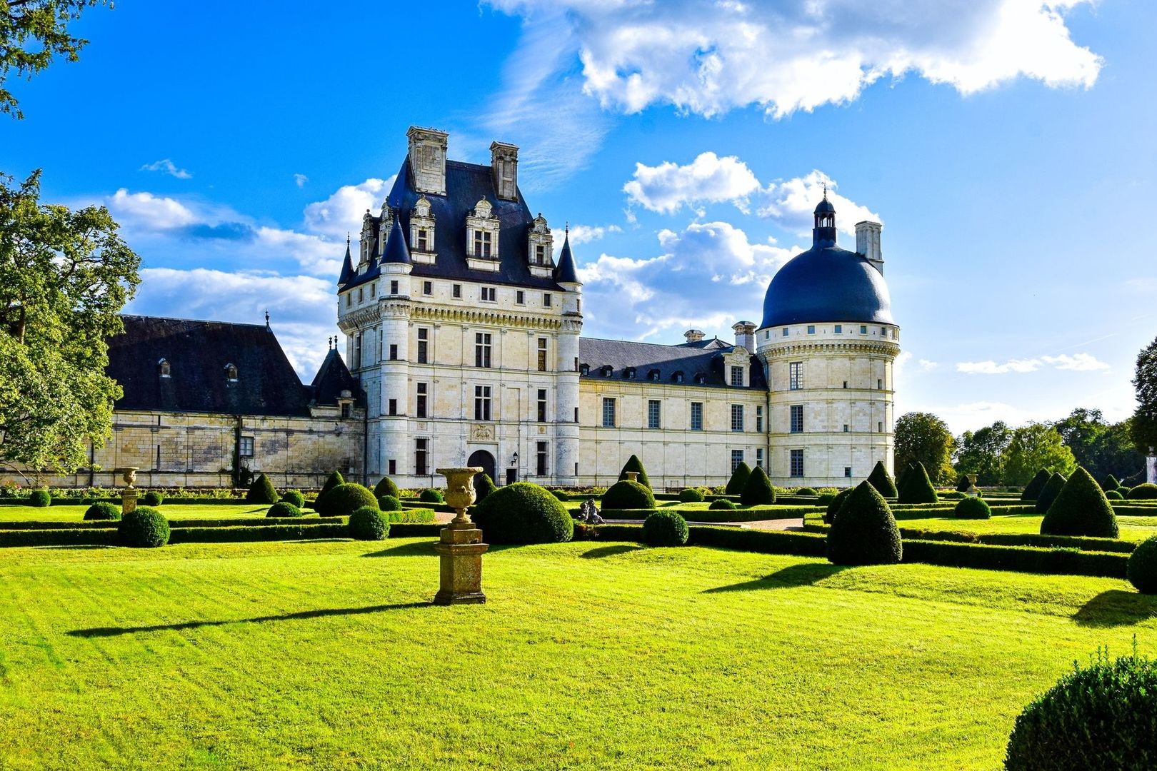 Château Renaissance et jardins à la française sous un ciel bleu